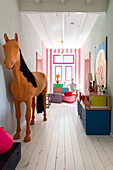 Flur mit dekorativem Pferd, farbigen Akzentmöbeln und Kunstwerk