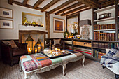 Rustic living room with fireplace, wooden beams and bookshelves