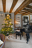 Christmas decorated room with wooden beamed ceiling, a grand piano and Christmas tree