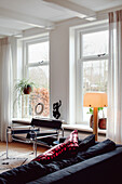 Bright living room with dark sofa and large windows