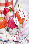 Tulpenblüten mit Namensschildern auf Eiern im Eierbecher