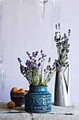 Lavender in two vintage ceramic vases, next to a bowl of apricots