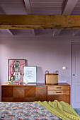 Retro sideboard with decoration in bedroom with exposed wooden beams