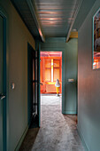 Hallway with green-painted walls and colour-contrasting room at the end