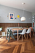 Essbereich mit Holztisch, Stühlen und Wanddekoration