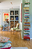 Wohnzimmer mit Wandregal für Bücher, Holzscheite und Stuhl mit Karomuster