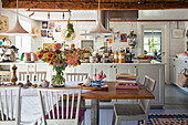 Country kitchen with dining table and bouquet of flowers