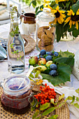 Gedeckter Gartentisch mit Sonnenblumen, Obst und selbstgemachten Leckereien