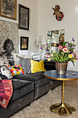 Living room with dark sofa, colourful cushions and side table
