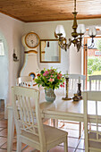 Dining area with wooden furniture and antique clock in light colors