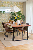 Dining area with wooden table, brown chairs and floral decorations