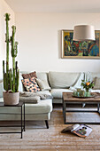 Bright living room with green cactus, corner sofa and coffee table
