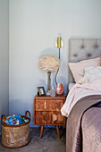Wooden bedside table with geometric pattern and bedside lamp in the bedroom