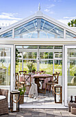 Conservatory with dining table and chairs, view of the garden