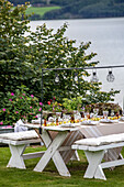 Set table for garden party with lake view and hanging lights