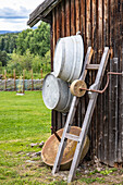 Zinc tubs and ladder at old wooden hut in rustic garden