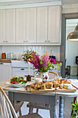 Country house kitchen with a laid table and fresh flowers