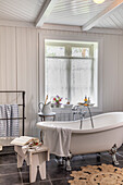 Freistehende Badewanne in Badezimmer im Landhausstil mit Holzverkleidung
