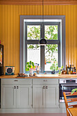 Country house kitchen with yellow wooden wall