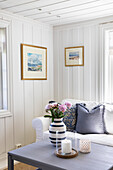 Maritime living room with throw pillows and vase of flowers