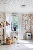 Brightly decorated children's room with floral wallpaper and play kitchen