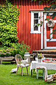 Garden party arrangement in front of red Swedish house in summer with chickens