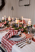 Festive dining table with candles and red and white chequered napkins