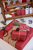 Weihnachtsgeschenke dekoriert mit Namensetiketten, Tannenzweigen und Zapfen