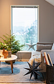 Wohnzimmer mit weihnachtlicher Dekoration und Blick durch ein großes Fenster ins Freie