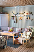 Rustikales Wohnzimmer mit Holzmöbeln und pastellgrüner Wandvertäfelung