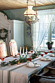 Festively laid table with candles and fir branches, country house style