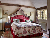 Schlafzimmer im Landhausstil mit Himmelbett und floraler Bettwäsche