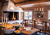 Cosy country-style dining area with open fireplace and rustic wooden elements