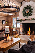 Rustic living room with fireplace, wooden furniture, chandelier and Christmas decorations