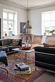 Living room with leather sofas, hanging lamp and patterned rug