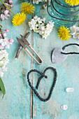 DIY heart made from string and florist's wire, dandelion (Taraxum) in a hanger jar, sprigs of lilac blossom (Syringa) and apple blossom
