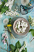 Wreath of lilac blossoms in a wooden bowl, bouquet of dandelions