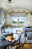 Small country-style kitchen with light blue cabinets in a tiny home