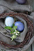 Arrangement with birch wreath and Easter eggs, dyed with red cabbage and beetroot