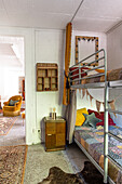 Metal bunk beds with patchwork quilts in a rustic children's room