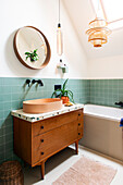 Modern bathroom with wooden washbasin and green tiles