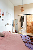 Bedroom with pink bed linen and wooden elements