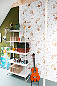Children's room with wall shelf, toy collection and guitar on patterned wall