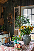Rustic dining table with a bouquet of sunflowers and a country-style fruit bowl