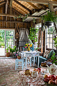 Garden house with rustic furnishings and colourful bouquet of flowers on the table