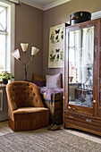 Retro armchair and antique wooden cabinet in cozy living room