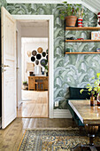 Living room with tropical patterned wallpaper and view of the adjoining room