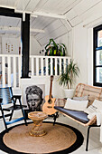 Living room on two levels with rattan bench, guitar and houseplants