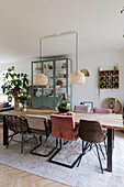 Dining table with chairs in different styles and rattan pendant lights