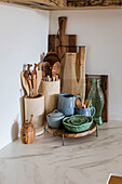 Küchenutensilien aus Holz und Keramik-Geschirr auf Arbeitsplatte